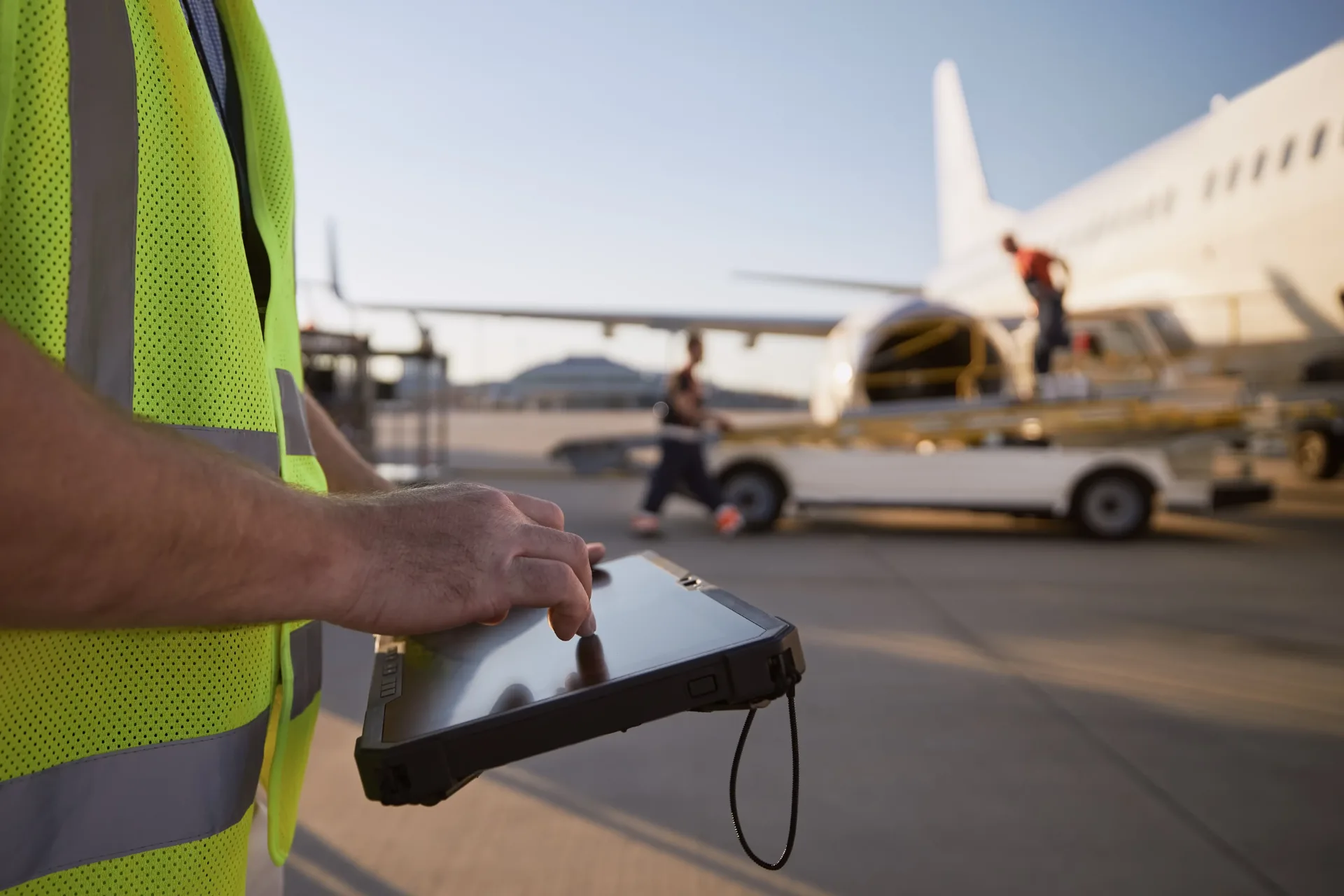 airport-worker-using-tablet-at-airplane-departure